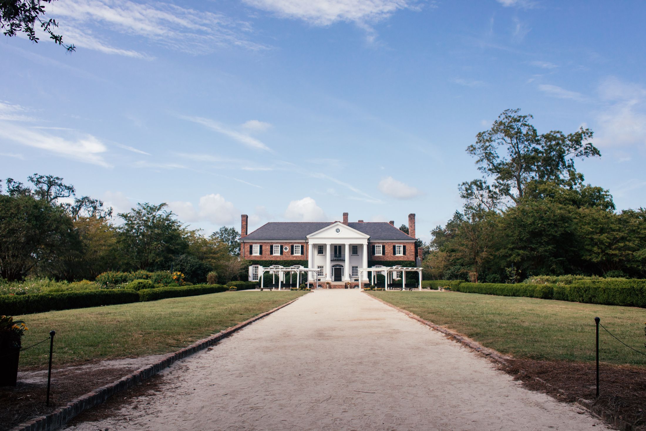 Picturesque view of Boone Hall Plantation's historic mansion in South Carolina under a blue sky.